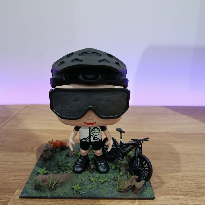 Mini-eu de ciclista com capacete roxo e bicicleta em diorama